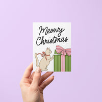 Meowy Christmas card detail — festive cat pawing at present greeting card by MangoIllustrated