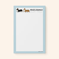 Mind Zoomies corgi notepad flat lay — funny corgi notepad for racing thoughts by indie artist MangoIllustrated