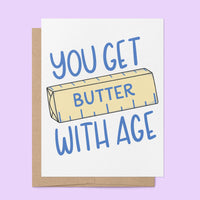 You Get Butter With Age birthday card flat lay — funny food pun card by indie artist MangoIllustrated