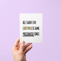 Holiday greeting card with bold black text reading “All I Want For Christmas is Some Precedented Times,” with "Christmas" in festive red and green letters.