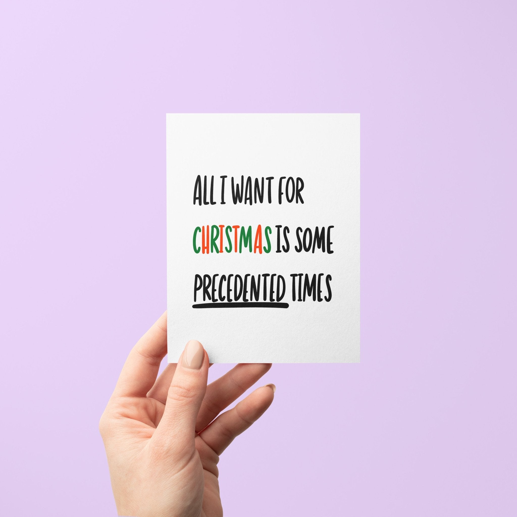 Holiday greeting card with bold black text reading “All I Want For Christmas is Some Precedented Times,” with "Christmas" in festive red and green letters.