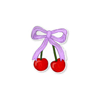 Vinyl sticker of two red cherries tied together with a lavender bow illustration.