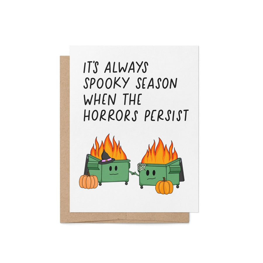 Funny Halloween card with two flaming dumpster illustrations, pumpkins, and the phrase “It’s Always Spooky Season When the Horrors Persist”