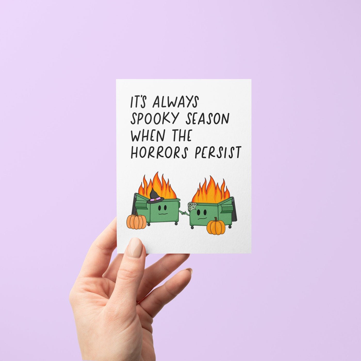 Funny Halloween card with two flaming dumpster illustrations, pumpkins, and the phrase “It’s Always Spooky Season When the Horrors Persist”