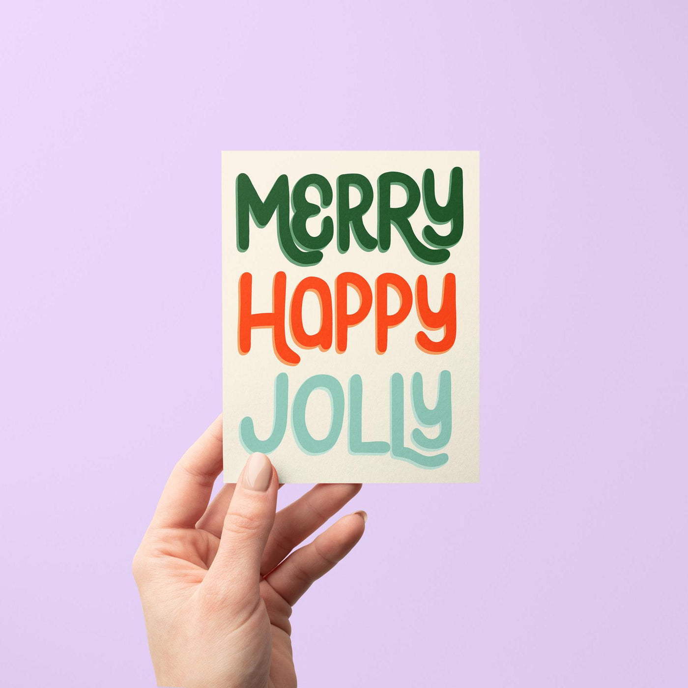 Celebrate the holiday season with this &quot;Merry Happy Jolly&quot; card. This hand lettered card features the greeting &quot;Merry Happy Jolly&quot; in fun hand lettering in shades of red, green, and blue.