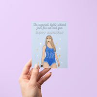 This Long Live Swiftie Hanukkah card features an illustration of Tay in a blue version of her Lover era Eras Tour bodysuit surrounded by stars against a light blue background. The greeting reads &quot;the menorah lights shined just for me and you.&quot;