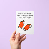 This card is a funny way to say happy holidays to the millennials in your life who still wear ankle socks. An illustration of socks is accompanied by the greeting &quot;Santa&#39;s out of coal. Hope he doesn&#39;t bring you ankle socks.&quot;