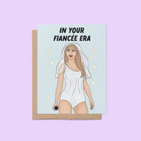 Engagement card with the phrase “In Your Fiancée Era” featuring an illustration of a woman in a sparkling outfit with a bridal veil and microphone.