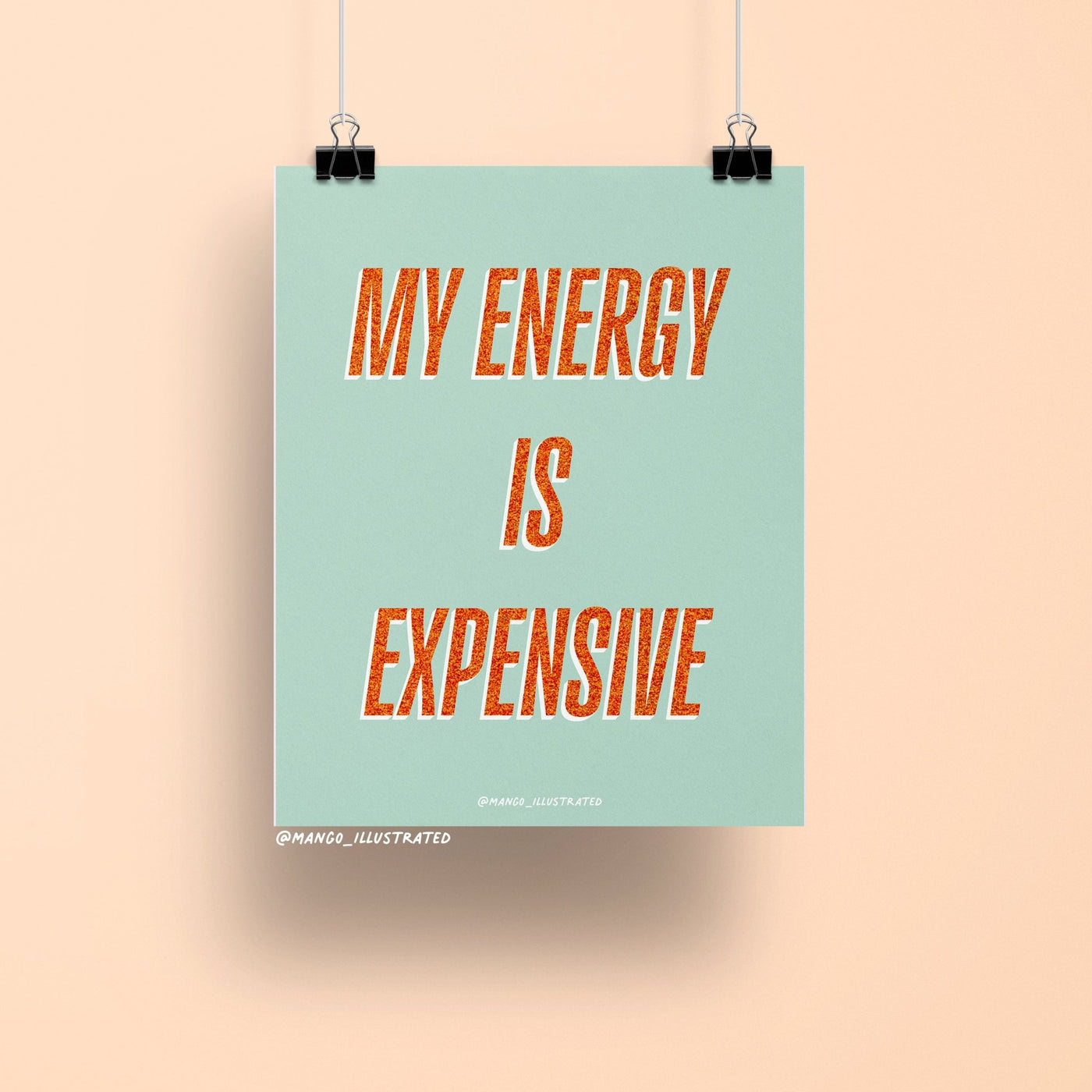 8x10 art print with bold orange glitter-style text reading “My Energy is Expensive” on a mint green background, printed on matte paper and packaged with cardboard backing in a cellophane sleeve.