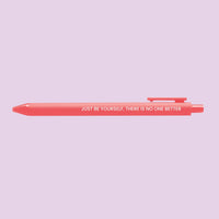 Neon coral pen with the motivational quote “Just be yourself, there is no one better” printed in white text.