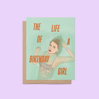 Taylor Swift-inspired birthday card titled “The Life of a Birthday Girl” featuring an illustrated glamorous woman in a sparkling, beaded-style outfit on a mint green background, paired with a kraft envelope.