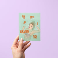 Taylor Swift-inspired birthday card titled “The Life of a Birthday Girl” featuring an illustrated glamorous woman in a sparkling, beaded-style outfit on a mint green background, paired with a kraft envelope.