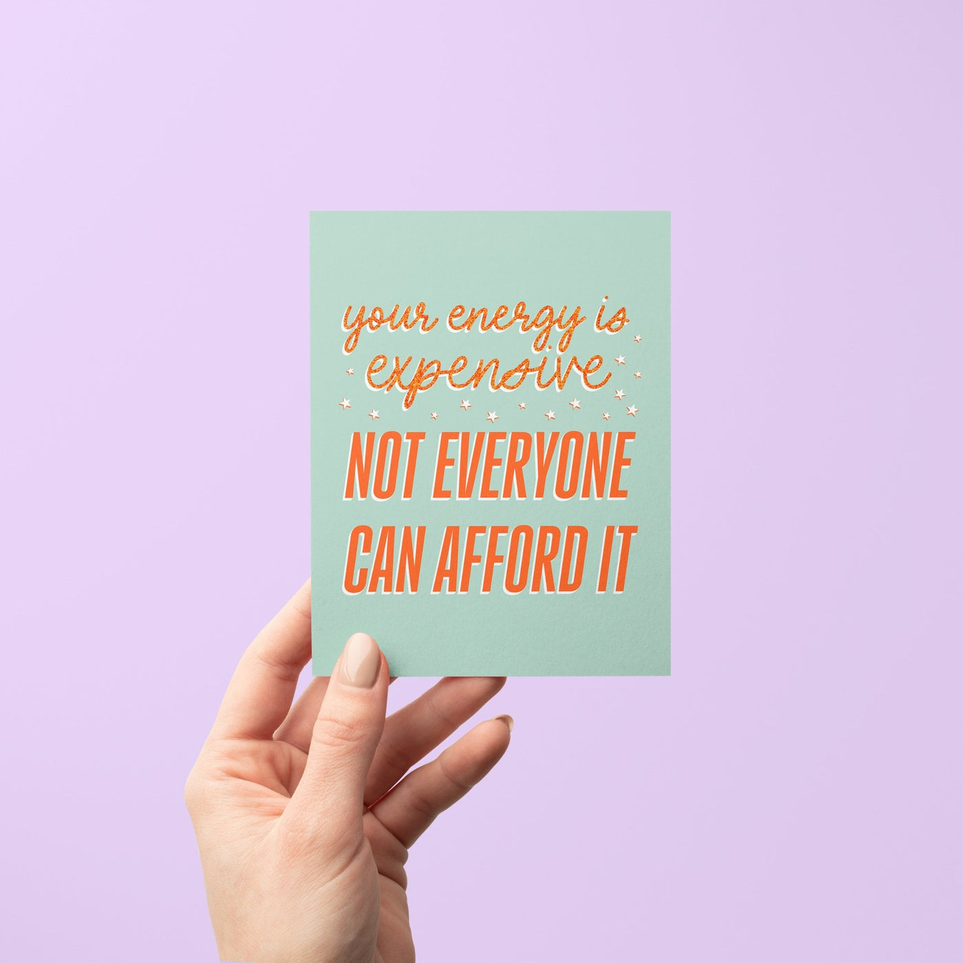 Hand holding a card with motivational text against a purple background