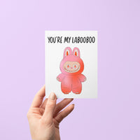 Greeting card with the phrase “You’re My Labooboo” above a cute pink monster illustration, blank inside with kraft envelope.